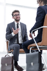 Two businessmen holding briefcases near themselves