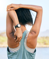 One active woman from the back stretching arms and triceps by pulling elbow towards spine while...