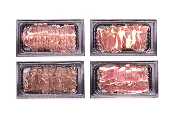 Set of raw sliced Dry Aged beef in black plastic tray isolated on white