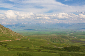 Aerial view over the valley and Talas Ala-Too and Suusamyr-Too ranges in the clouds from Ala Bel pass. Kyrgyzstan