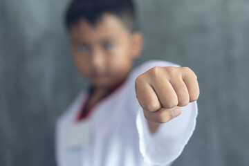 Asian boy clenching fists to practice taekwondo, Taekwondo martial art, selective focus detail on...