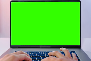 Laptop green screen on wood table with typing hand. office work