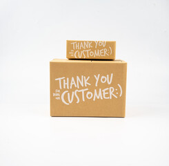 Two closed cardboard boxes taped up, and there is a Thank you for being our customer beside the parcel box for delivery and shopping online concept design isolated on white background.