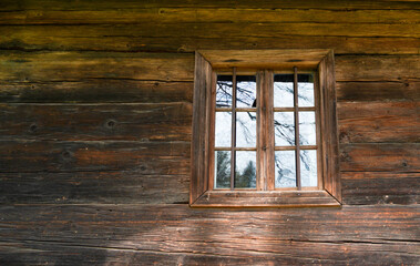 Obraz na płótnie Canvas Aged wooden window with glazing and partially weathered in rustic homes