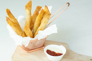 Homemade Fried Breaded mozzarella cheese sticks served with tomato sauce and mayonnaise on white background