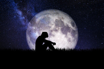 silhouette of a person in the night. heartbroken and lonely man On the background of the beautiful moon. Image elements furnished by NASA.