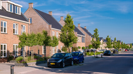 Dutch Suburban area with modern family houses, newly build modern family homes in the Netherlands, dutch family houses, and apartment houses. In the Netherlands, newly build streets with modern house - obrazy, fototapety, plakaty