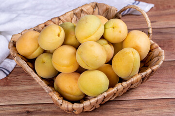 Apricots on wood background. A pile of fresh apricots in a basket. close up
