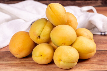 Naklejka na ściany i meble Apricots on wood background. Pile of fresh apricots. close up