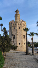 Fototapeta na wymiar Seville, Spain, September 12, 2021: The Tower of Gold at the Quidalquivir in Sevilla. The Golden Tower is one of Seville's iconic landmarks. La Torre del Oro is a military observation tower.