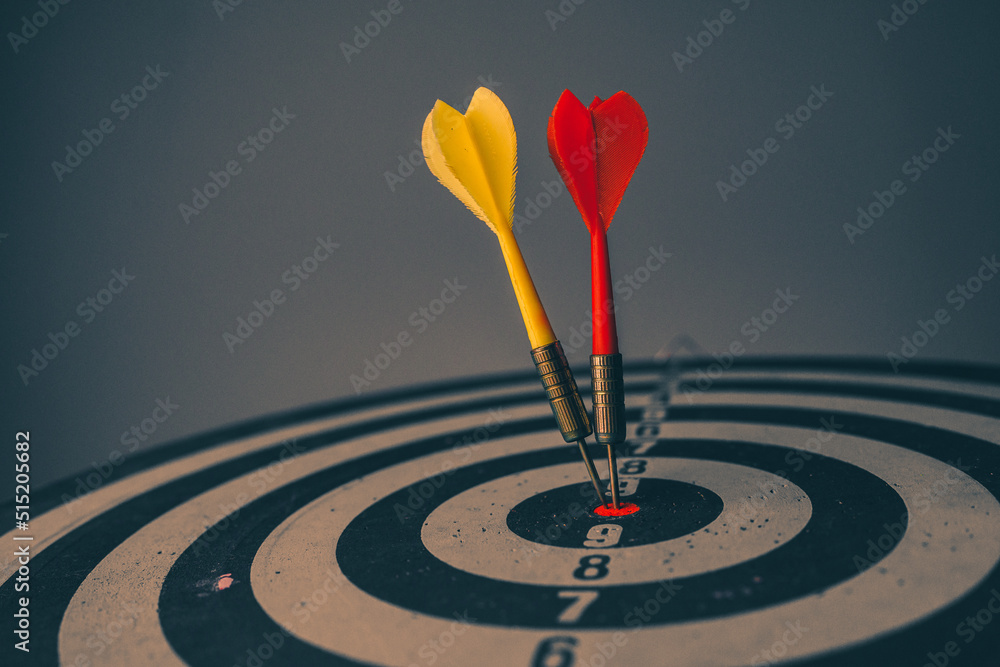 Poster close up shot of the dart arrow hit on bulleyes of dartboard to represent that the business reached 