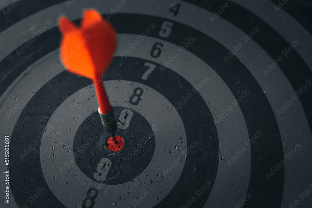 Poster close up shot of the dart arrow hit on bulleyes of dartboard to represent that the business reached 