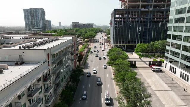 Aerial above car traffic in USA city. Rising aerial reverse dolly shot.