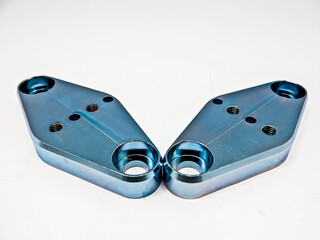 Iron metal, stainless steel, aluminum, chrome plated, silver bronze mixed with blue, 2 pieces perforated, screwed, facing each other, placed on a white background.