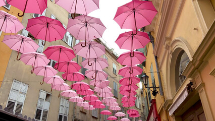 Suspended pink umbrellas in the historic center of Grasse, celebrating the Rose Expo in...