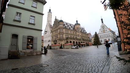 Fototapeta premium Rothenburg ob der Tauber, Germany, December 8, 2021: The Market Square and Town Hall Tower, with its grand stairs, the Renaissance façade and surrounded by the romantic timber-frame buildings.