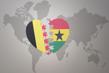 puzzle heart with the national flag of belgium and ghana on a world map background.Concept.
