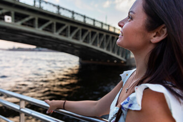 Russia. Saint-Petersburg. A girl on the deck of a pleasure steamer sails under the Trinity Bridge.