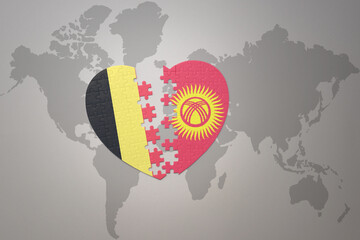 puzzle heart with the national flag of belgium and kyrgyzstan on a world map background.Concept.