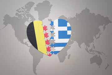 Fototapeta premium puzzle heart with the national flag of belgium and greece on a world map background.Concept.