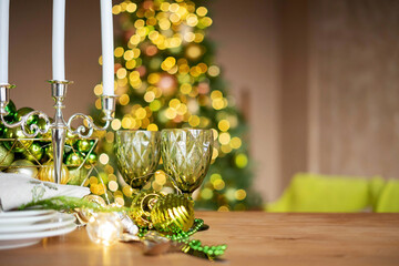 Preparing for Christmas table setting: Candlestick, plates, wine glasses with copy space.