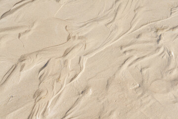 Fototapeta na wymiar Above view of beach sand with wind swept patterns from gust winds with copy space. Closeup of detail and texture background with copyspace of erosion from climate change and global warming on land