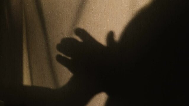 Silhouette of a male hand touching the skin of a partner, close-up