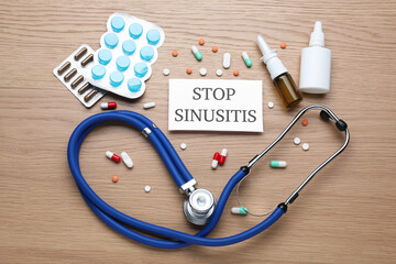 Flat lay composition of card with words Stop Sinusitis, stethoscope and remedies on wooden table