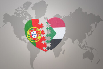 puzzle heart with the national flag of portugal and sudan on a world map background.Concept.