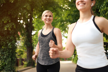 Fototapeta premium Women running on city street in morning