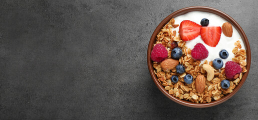 Tasty homemade granola with berries served on grey table, top view with space for text. Banner...