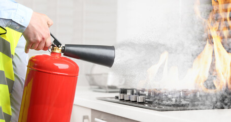 Man putting out burning cooktop with fire extinguisher in kitchen, closeup. Banner design