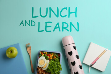 Lunch and Learn concept. Flat lay composition with thermos, food and stationery on light blue...