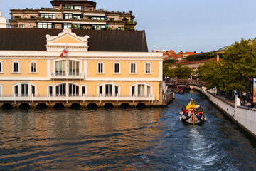 Naklejka premium Aveiro, Portugal, August 21, 2021: View of the main city canal in Aveiro and Vouga River with traditional Moliceiro boats (gondolas) on the canal. Moliceiro transporting tourists.