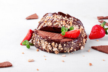 Sweet tacos with chocolate thin waffle and ice cream topped with nuts and strawberry on the white table. Dessert variation of Mexican classics