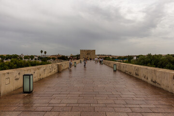 Obraz premium Cordoba, Spain, September 13, 2021: The defensive tower from the Muslim era: the Calahorra Tower, Guadalquivir River, and the Roman Bridge.