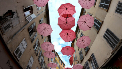 Suspended pink umbrellas in the historic center of Grasse, celebrating the Rose Expo in...