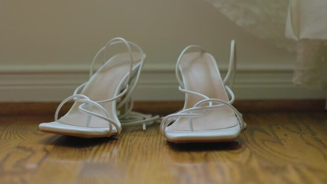 Beautiful white lace wedding shoes fashionable designer high heels on hardwood floor