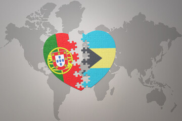 puzzle heart with the national flag of portugal and bahamas on a world map background.Concept.