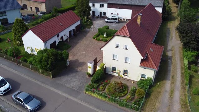 Farm vacation camp 
Buttery soft aerial view flight fly backwards drone footage
at Countryside village Hainichen in Europe Saxony Anhalt, summer 2022. 4k Cinematic view from above by Philipp Marnitz