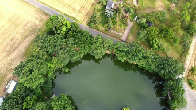 Small lake in the middle of fields.
Gorgeous aerial view flight tilt up drone footage at Countryside village Hainichen in Europe Saxony Anhalt, summer 2022. 4k Cinematic from above by Philipp Marnitz