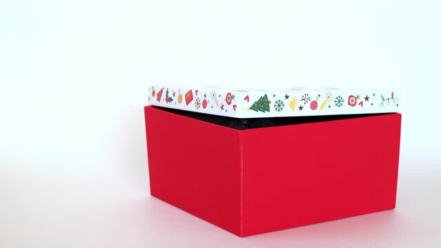 Sniffing nose of black rabbit hiding in a red gift box isolated on a white background. Hare is the symbol for 2023 according to the eastern calendar. Holiday gift surprise for Christmas and New Year.