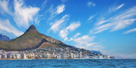 Copy space, panorama seascape with clouds, blue sky, hotels, and apartment buildings in Sea Point, Cape Town, South Africa. Lions head mountain overlooking the beautiful blue ocean peninsula