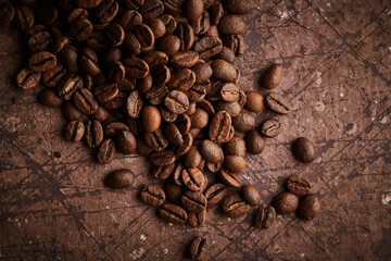 Roasted coffee beans isolated close up on brown grunge background