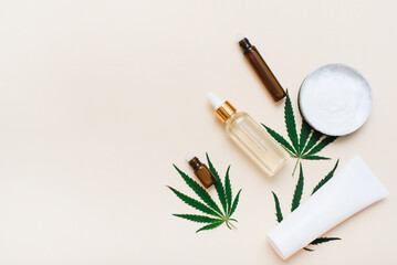 Cosmetics with hemp extract on a beige background with copy space.