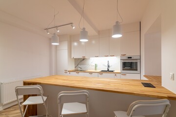 Modern apartment kitchen with a counter and three bar stools