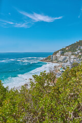Scenic seascape of Clifton beach, Cape Town, South Africa with hotels and holiday houses situated on a beachfront. Beautiful rock outcrops of mountaintops and nature near the coastline or bay