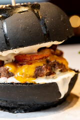 Big black juicy brown burger a black background close up fast food