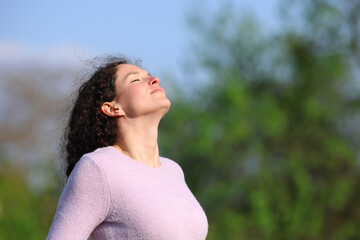 Woman with curly hair breaths fresh air