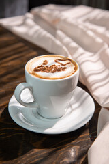 Isolated cappuccino with decorated topping in a white cup on red background copy space
